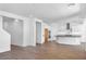 Bright open-concept living room featuring wood-look floors, white walls, kitchen access and recessed lights at 9036 S 196Th Dr, Goodyear, AZ 85338