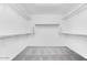 Empty walk-in closet with carpet flooring and shelving and hanging rods for storage at 9036 S 196Th Dr, Goodyear, AZ 85338