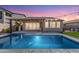 Stunning backyard oasis with a sparkling pool, covered patio, and string lights at 11682 W Parkway Ln, Avondale, AZ 85323