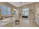 Luxurious bathroom with soaking tub, double vanity, and a view of the bedroom at 18125 W Acacia Dr, Goodyear, AZ 85338