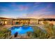 Luxury backyard oasis featuring a sparkling pool, expansive patio, and a pergola-covered dining area at 18125 W Acacia Dr, Goodyear, AZ 85338