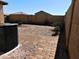 Backyard view with brick patio, gravel, and AC unit at 21963 W Gardenia Dr, Buckeye, AZ 85326