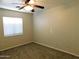 Bright bedroom with ceiling fan, large window, and plush carpeting at 21963 W Gardenia Dr, Buckeye, AZ 85326