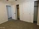 Spacious bedroom with plush carpeting, sliding closet doors, and access to hallway at 21963 W Gardenia Dr, Buckeye, AZ 85326