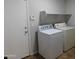 Bright laundry room features washer, dryer, and shelving at 21963 W Gardenia Dr, Buckeye, AZ 85326