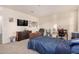 Well-lit bedroom with a large TV and comfortable seating at 24413 W Raymond St, Buckeye, AZ 85326