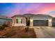Single-story home with gray exterior, two-car garage, and landscaped yard at 24413 W Raymond St, Buckeye, AZ 85326