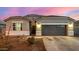 Single-story home with gray exterior, two-car garage, and landscaped yard at 24413 W Raymond St, Buckeye, AZ 85326