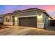 Single-story home with gray exterior, two-car garage, and landscaped yard at 24413 W Raymond St, Buckeye, AZ 85326