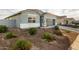 Single-story home with gray exterior, two-car garage, and landscaped yard at 24413 W Raymond St, Buckeye, AZ 85326