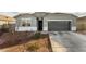 Single-story home with gray exterior, two-car garage, and landscaped yard at 24413 W Raymond St, Buckeye, AZ 85326