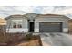 Single-story home with gray exterior, two-car garage, and landscaped yard at 24413 W Raymond St, Buckeye, AZ 85326
