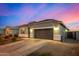 Single-story home with gray exterior, two-car garage, and landscaped yard at 24413 W Raymond St, Buckeye, AZ 85326
