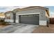 Gray exterior, two-car garage, and driveway at 24413 W Raymond St, Buckeye, AZ 85326