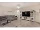 Spacious living room with sectional sofa, large TV, and tile floors at 24413 W Raymond St, Buckeye, AZ 85326
