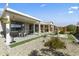 Lush backyard featuring a covered patio, dining area, and decorative landscaping with rocks at 27395 W Wahalla Ln, Buckeye, AZ 85396
