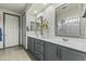 Updated bathroom featuring dual sinks, framed mirrors, gray cabinets, and a tile floor at 27395 W Wahalla Ln, Buckeye, AZ 85396