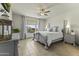 Comfortable main bedroom featuring soft lighting, a ceiling fan, and an outdoor view at 27395 W Wahalla Ln, Buckeye, AZ 85396