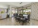 Well-lit dining room with a large table, patterned wallpaper, and sliding doors leading to outdoor space at 27395 W Wahalla Ln, Buckeye, AZ 85396