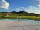 Relax in this infinity pool with stunning views of a lush green golf course and picturesque mountains in the background at 27395 W Wahalla Ln, Buckeye, AZ 85396