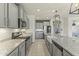 Spacious modern kitchen featuring stainless steel appliances, white cabinets, and granite countertops at 27395 W Wahalla Ln, Buckeye, AZ 85396