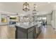 Open-concept kitchen with gray cabinets, granite counters, modern lighting, and stainless appliances in a neutral color palette at 27395 W Wahalla Ln, Buckeye, AZ 85396