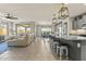 Spacious living room area featuring tile floors, modern fixtures, large windows, and open access to the kitchen at 27395 W Wahalla Ln, Buckeye, AZ 85396