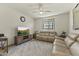 Relaxing living room with leather sofas, ceiling fan, and mounted TV at 27395 W Wahalla Ln, Buckeye, AZ 85396