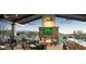 Covered outdoor dining area with a cozy fireplace, TV and scenic views of the golf course for a great experience at 27395 W Wahalla Ln, Buckeye, AZ 85396