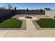 Landscaped backyard with artificial turf and fire pit at 28756 N Desert Hills Dr, San Tan Valley, AZ 85143