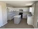 Modern kitchen with white cabinets, center island, and stainless steel appliances at 28756 N Desert Hills Dr, San Tan Valley, AZ 85143