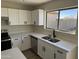 Modern kitchen with white cabinets, quartz countertops, and stainless steel appliances at 28756 N Desert Hills Dr, San Tan Valley, AZ 85143