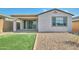 Back exterior of the home shows the covered patio, gravel landscaping, and a small patch of synthetic grass at 32034 N 125Th Ave, Peoria, AZ 85383