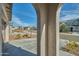 Arched entry view of a suburban street lined with houses, green lawns, and growing trees at 32034 N 125Th Ave, Peoria, AZ 85383
