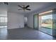 Bright living room boasts tile flooring, ceiling fan, and sliding glass doors to the backyard at 32034 N 125Th Ave, Peoria, AZ 85383