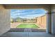 Covered patio view looking out to gravel landscaping, block wall, and synthetic grass at 32034 N 125Th Ave, Peoria, AZ 85383