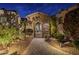 Stone archway entrance to a private courtyard with lighting and landscaping at 3330 S Sycamore Village Dr, Gold Canyon, AZ 85118