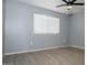 Simple bedroom with wood-look flooring and large window at 3331 W Del Monico Ln, Phoenix, AZ 85051