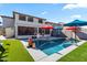 Relaxing backyard oasis featuring a sparkling pool, covered patio, and lush grass at 38100 W Santa Clara Ave, Maricopa, AZ 85138