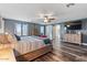 Spacious main bedroom with a barn door, large TV, and plenty of natural light at 38100 W Santa Clara Ave, Maricopa, AZ 85138