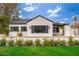 Charming white brick home with black trim, complemented by a well-maintained lawn and a white flower bed at 412 W Vermont W Ave, Phoenix, AZ 85013