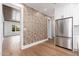 Modern hallway featuring stainless steel refrigerator, wood floors, designer wallpaper, and open doorways at 412 W Vermont W Ave, Phoenix, AZ 85013