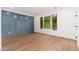 Bright living room featuring hardwood floors, white trim, and blue accent wall at 412 W Vermont W Ave, Phoenix, AZ 85013