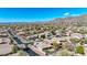 Aerial view of a desert community nestled against a mountain range, featuring lush landscaping and private pools at 41216 N Shadow Creek Ct, Anthem, AZ 85086