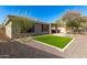 Backyard featuring an artificial grass area, gravel landscaping, and a covered patio at 41216 N Shadow Creek Ct, Anthem, AZ 85086