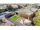Aerial view of a private backyard featuring synthetic grass, mature shade tree, and a secure wrought iron fence at 41216 N Shadow Creek Ct, Anthem, AZ 85086