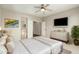 Bright bedroom with ceiling fan, light walls, adjacent closet and bathroom, and comfortable bed at 41216 N Shadow Creek Ct, Anthem, AZ 85086