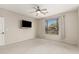 Bright bedroom featuring a ceiling fan, neutral walls, and a large window overlooking the landscape at 41216 N Shadow Creek Ct, Anthem, AZ 85086