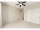 This bedroom has neutral walls and carpet, a ceiling fan, closet, and a doorway to another room at 41216 N Shadow Creek Ct, Anthem, AZ 85086