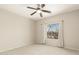 Bright bedroom with neutral walls and carpet, ceiling fan, and a view of the outdoors through the window at 41216 N Shadow Creek Ct, Anthem, AZ 85086
